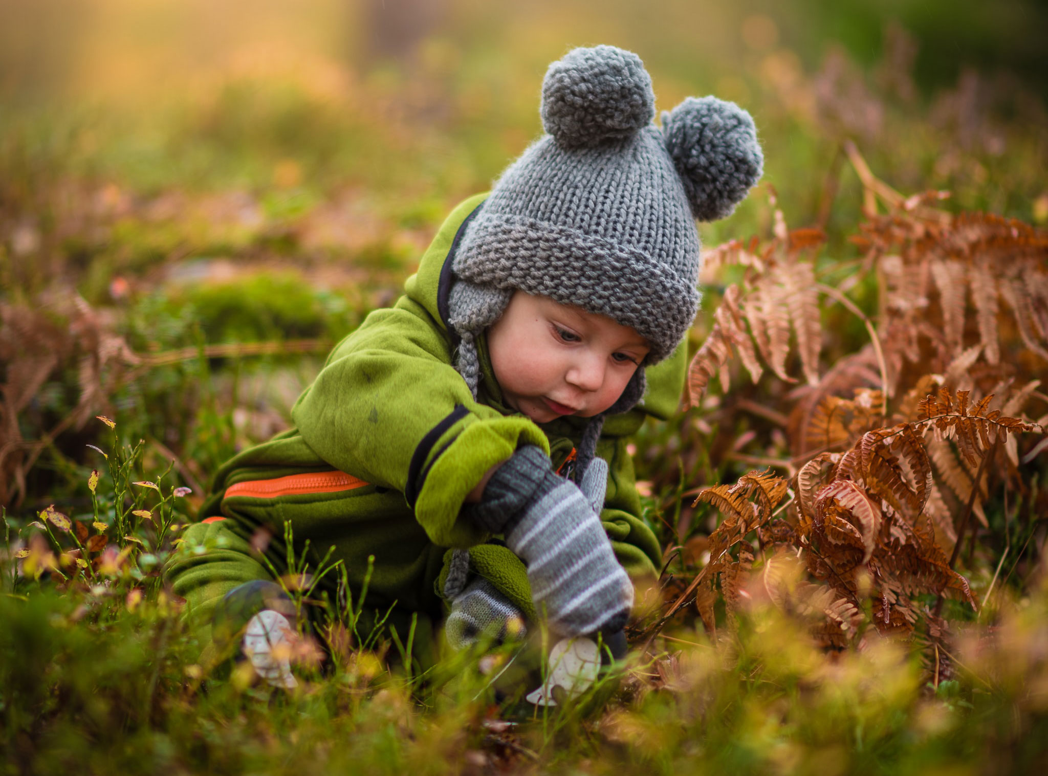 Enfant bébé avec un bonnet qui joue dans la forêt Enfant bébé avec un bonnet qui joue dans la forêt
