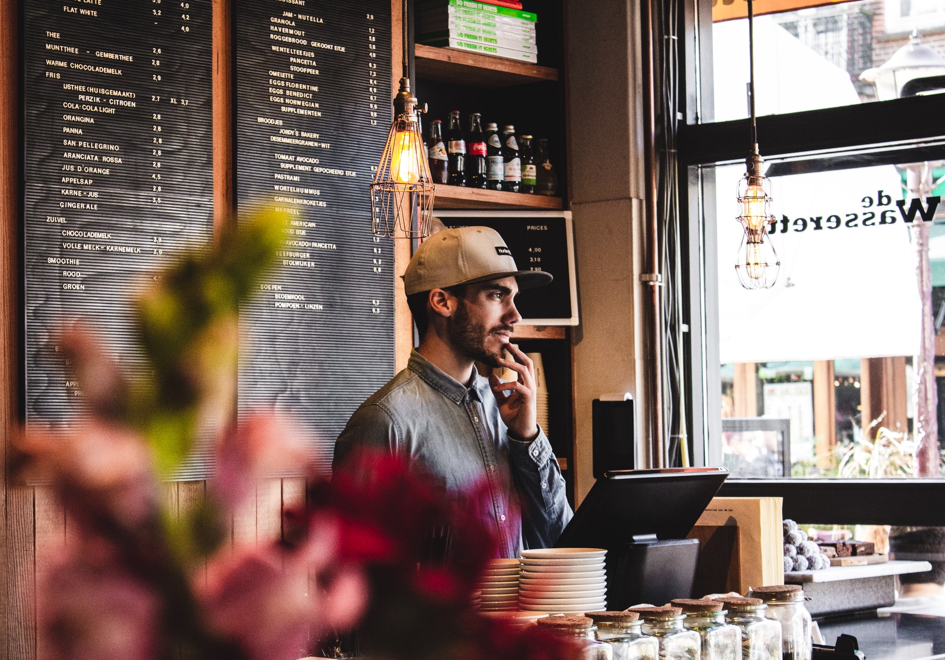 Serveur qui a un travail sans diplôme et qui attend devant une caisse enregistreuse Serveur qui a un travail sans diplôme et qui attend devant une caisse enregistreuse
